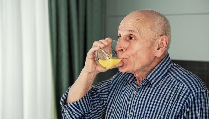 older gentleman drinking orange juice