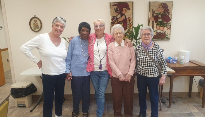 women standing indoors for a group photo