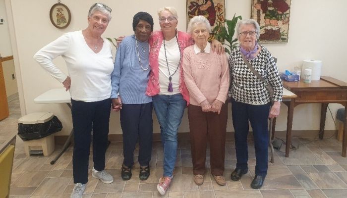 a group of older women standing side by side for a friendly photo