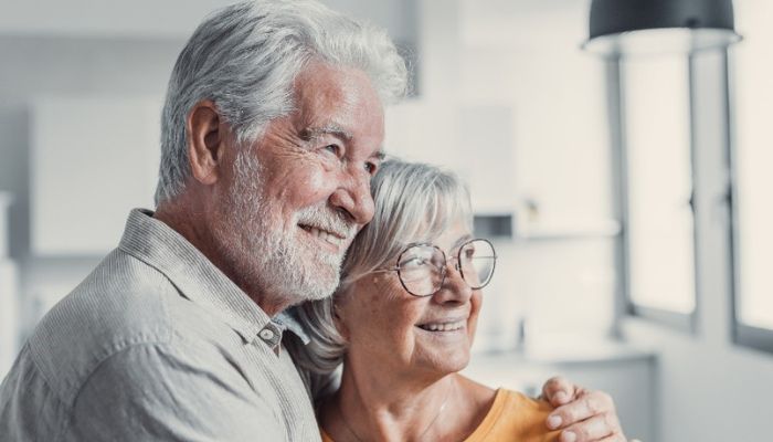 older couple embraced looking out a window