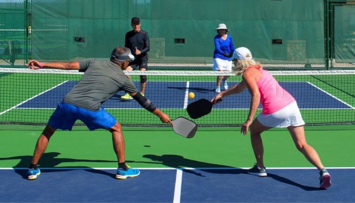 two couples playing pickleball