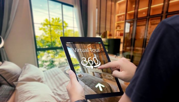 a hadn holding a tablet with "virtual tour 360)" on the screen.