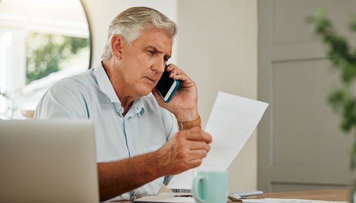 man on the phone reading from a paper