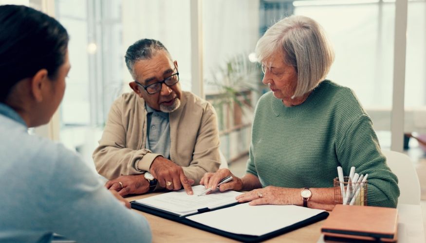 a older couple sitting with an advisor looking over a will