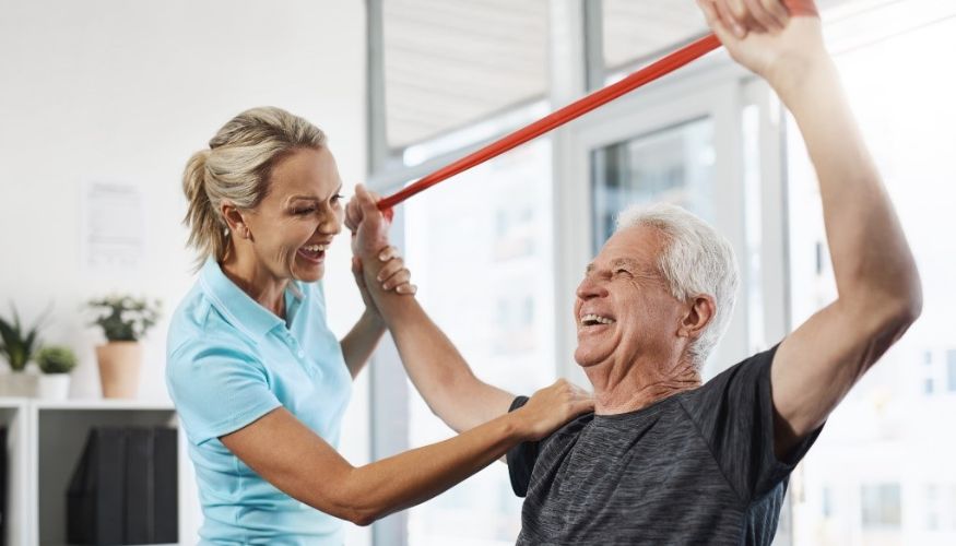 PT treating a man while using a thera-band