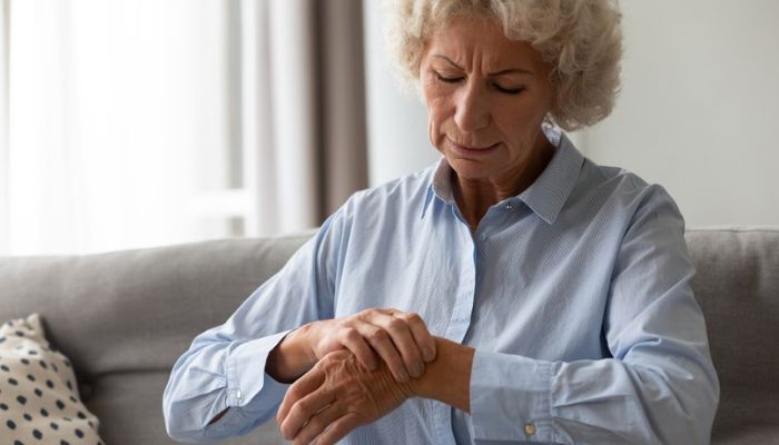 woman holding her hand that is in pain