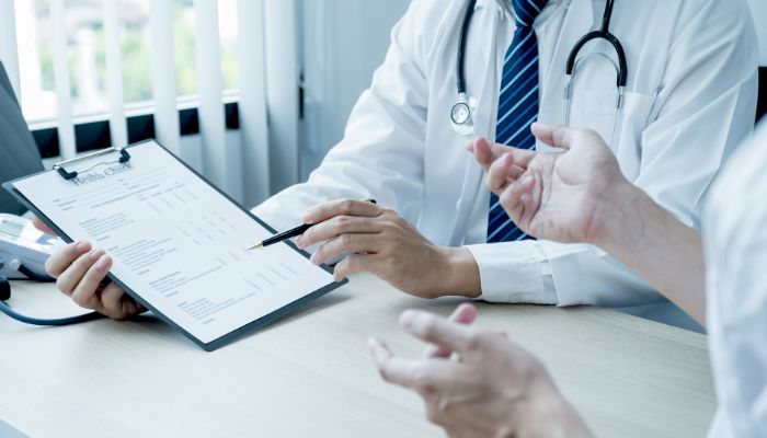 doctor pointing to clipboard with things to go over with patient