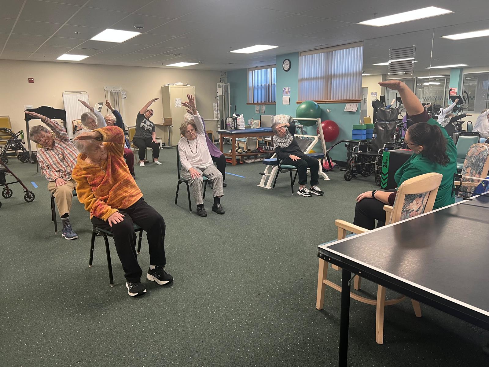 Seniors working out while sitting in chairs