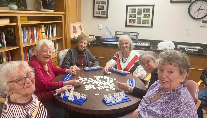 a group of women sitting around a table playing a game 