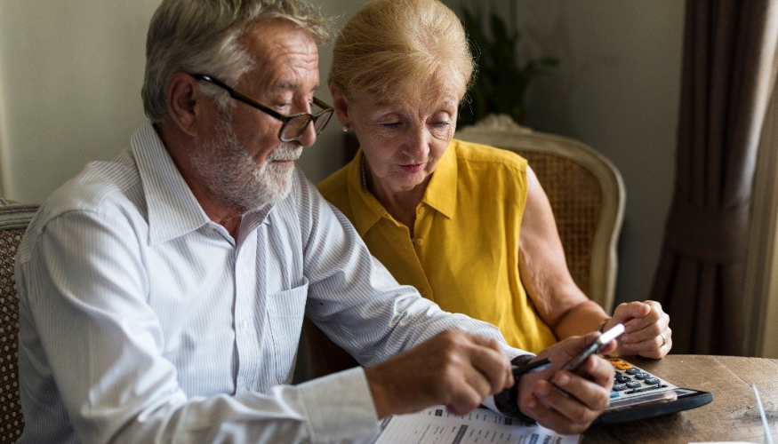 couple looking over bills together using a calculator